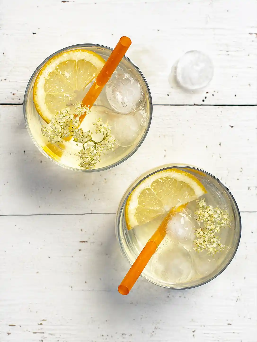 Holunderblütensirup Rezept mit Zitronen, Eiswürfeln und Holunderblüten als erfrischendes Sommergetränk