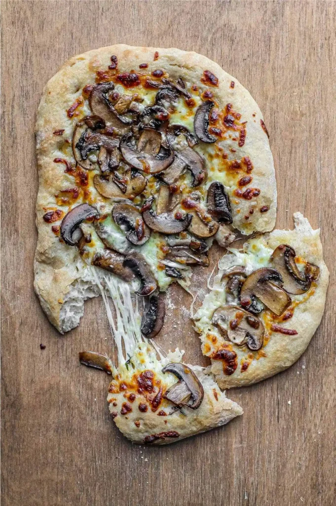 Pinsa Rezept mit luftigem Pinsa Teig, Pilzen und geschmolzenem Mozzarella als herzhafter Pinsa Belag