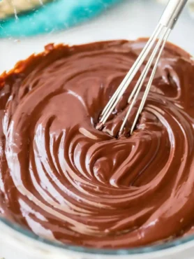 Schokolade Ganache Rezept mit glatter Schoko Ganache, die in einer Glasschüssel cremig gerührt wird
