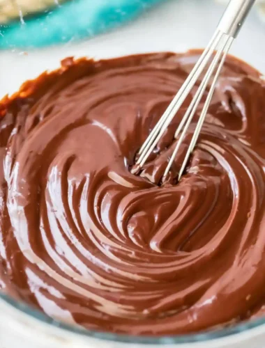 Schokolade Ganache Rezept mit glatter Schoko Ganache, die in einer Glasschüssel cremig gerührt wird