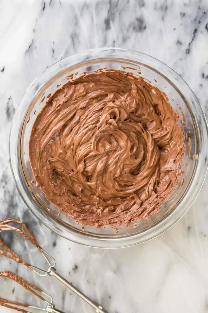 Aufgeschlagene Schoko Ganache in einer Glasschüssel als cremige Ganache Tortenfüllung für Schokolade Ganache Rezept