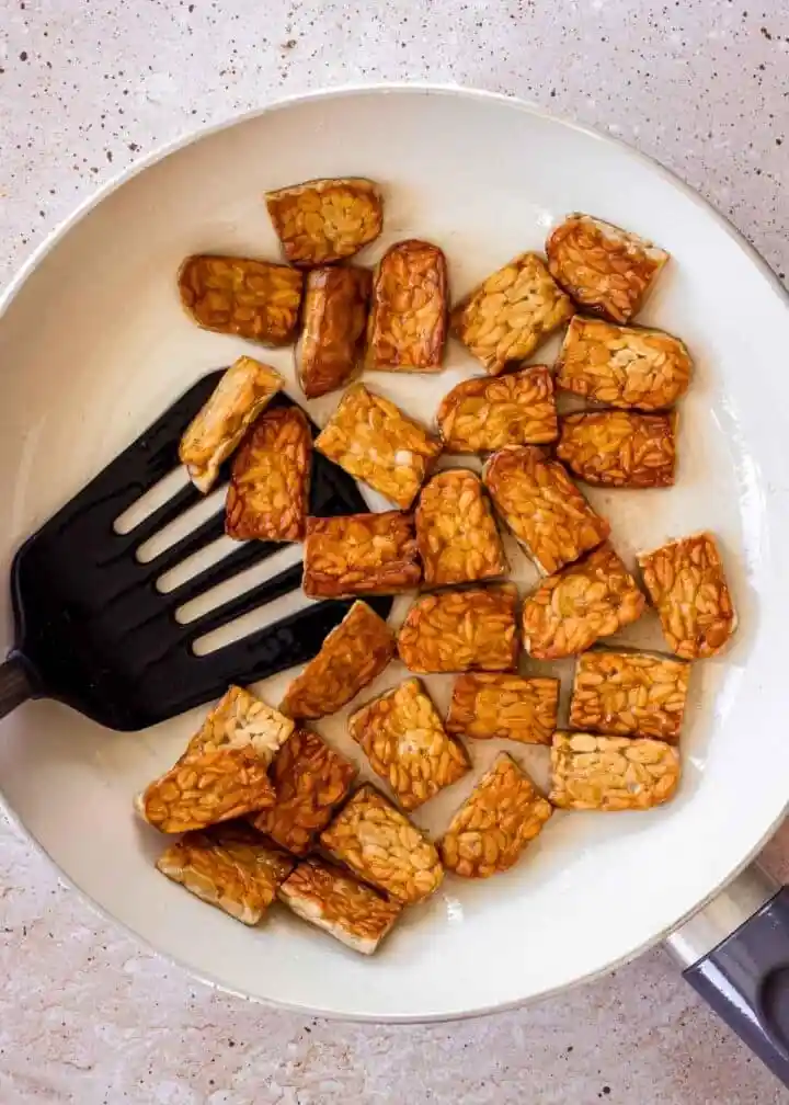 Tempeh zubereiten und braten mit goldbraunem Tempeh in der Pfanne als einfaches Tempeh Rezept