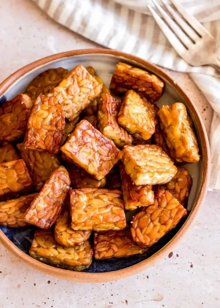 Tempeh zubereiten und braten als goldbraune Tempeh-Stücke in einer Schüssel für einfache Tempeh Gerichte