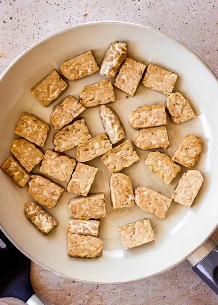 Tempeh zubereiten und braten mit Tempeh-Stücken in der Pfanne als einfaches Tempeh Rezept