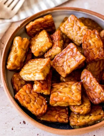 Tempeh zubereiten und braten mit goldbraunen Tempeh-Stücken in einer Schüssel als einfaches Tempeh Rezept