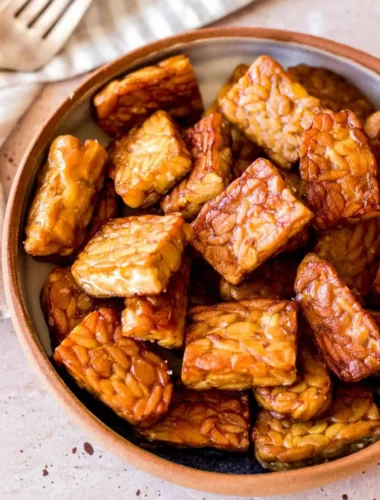 Tempeh zubereiten und braten mit goldbraunen Tempeh-Stücken in einer Schüssel als einfaches Tempeh Rezept