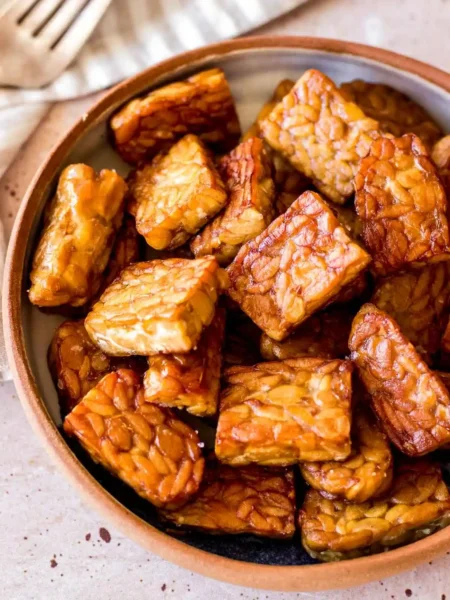 Tempeh zubereiten und braten mit goldbraunen Tempeh-Stücken in einer Schüssel als einfaches Tempeh Rezept
