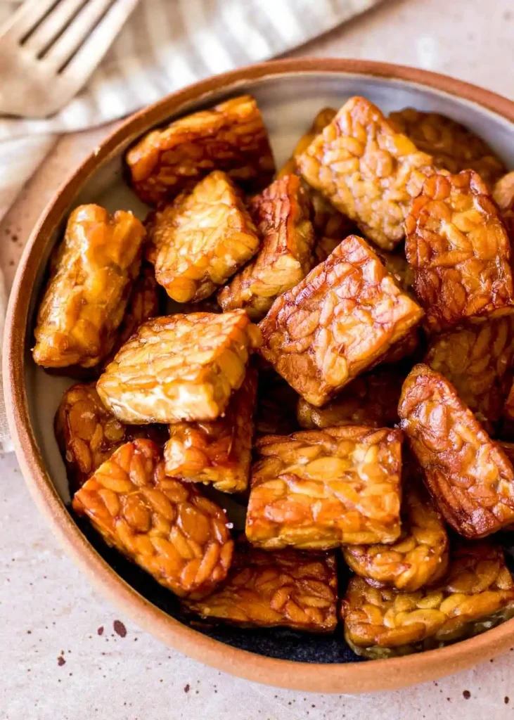 Tempeh zubereiten und braten mit goldbraunen Tempeh-Stücken in einer Schüssel als einfaches Tempeh Rezept