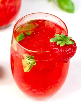 Erdbeerlimes alkoholfrei im Glas mit frischen Erdbeeren, Basilikum, Eis und spritzigem Mineralwasser
