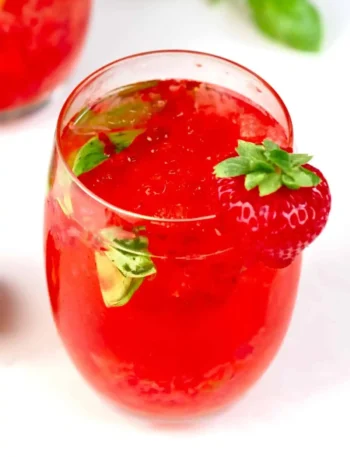 Erdbeerlimes alkoholfrei im Glas mit frischen Erdbeeren, Basilikum, Eis und spritzigem Mineralwasser