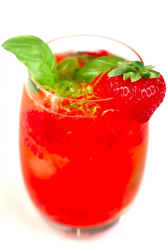 Erdbeerlimes alkoholfrei im Glas mit frischer Erdbeere, Basilikum, Limette und Eiswürfeln