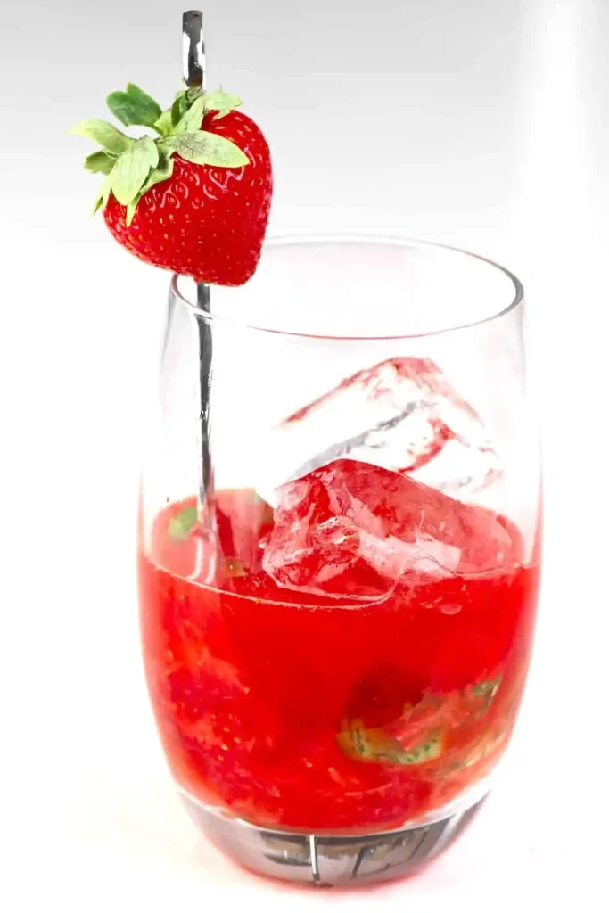 Erdbeerlimes alkoholfrei im Glas mit Eiswürfeln, frischen Erdbeeren und Limette