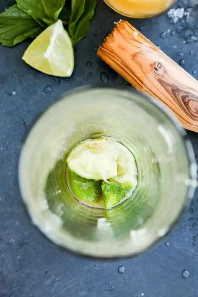 Ipanema Cocktail zubereiten mit frischer Limette, Rohrzucker und Stößel für alkoholfreies Ipanema Rezept