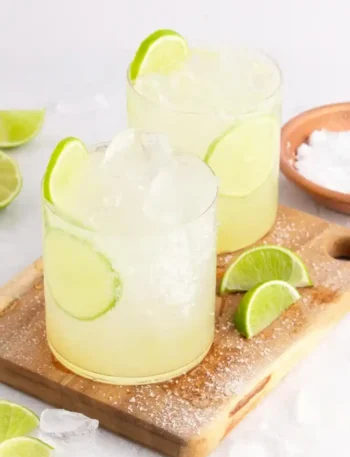 Zwei Gläser Margarita ohne Alkohol mit Eiswürfeln, Limettenscheiben und grobem Meersalz