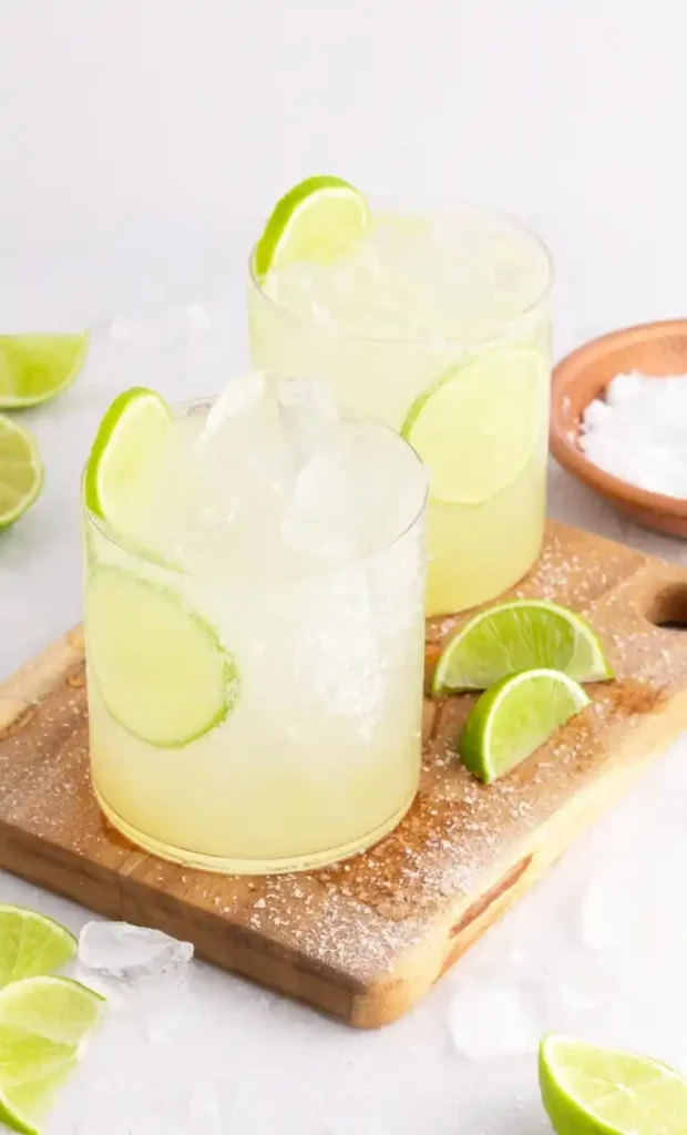 Zwei Gläser Margarita ohne Alkohol mit Eiswürfeln, Limettenscheiben und grobem Meersalz
