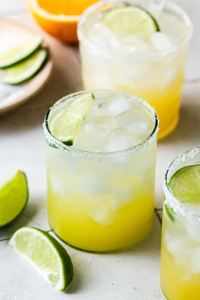 Drei Gläser Margarita ohne Alkohol mit Eis, Limettenspalten und klassischem Salzrand