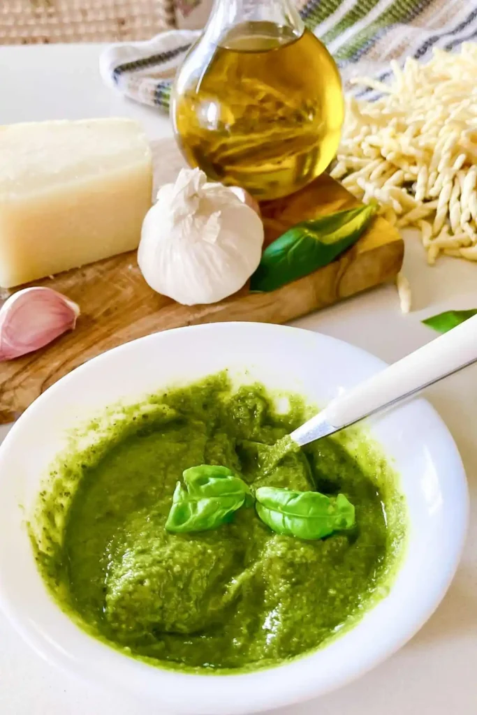 Selbst gemachtes grünes Basilikum-Pesto Genovese in einer weißen Schale mit Basilikum, Knoblauch, Parmesan, Olivenöl und Trofie.