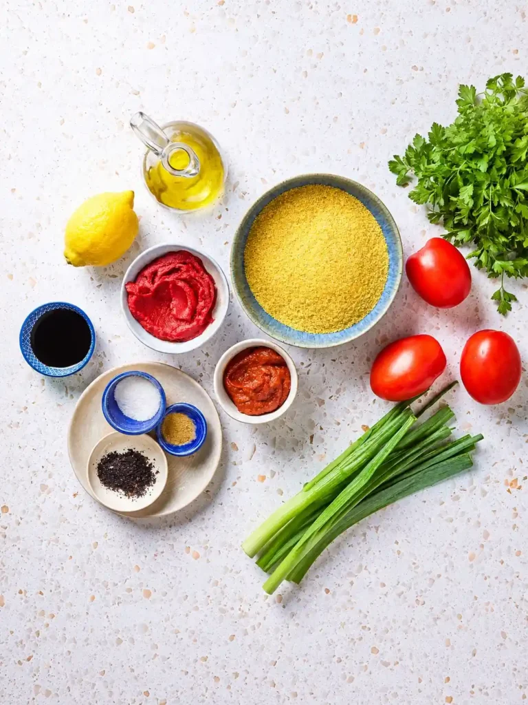 Kısır-Zutaten für türkischen Bulgursalat mit feinem Bulgur, Tomaten, Petersilie, Frühlingszwiebeln, Paprikamark und Granatapfelsirup