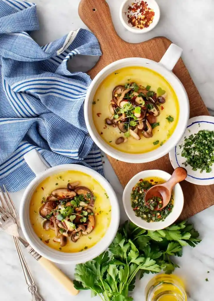Cremige Polenta mit Parmesan, gebratenen Pilzen und frischen Kräutern nach italienischem Rezept