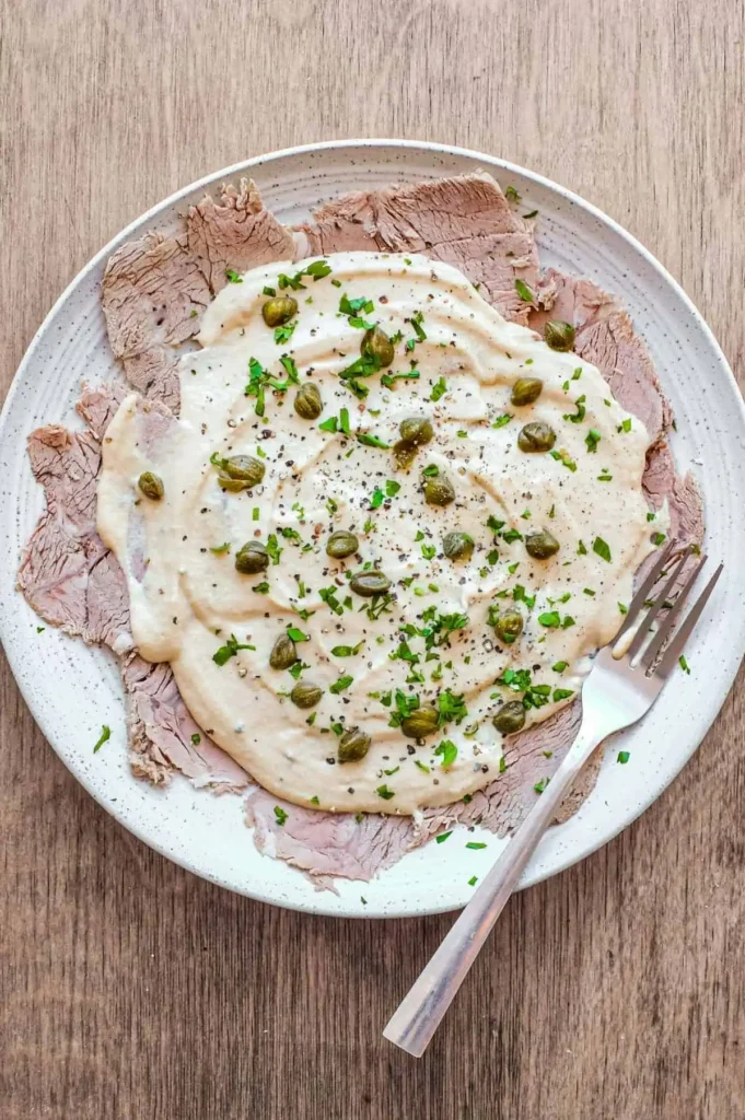 Vitello Tonnato mit dünn geschnittenem Kalbfleisch, cremiger Thunfischsauce, Kapern und Petersilie
