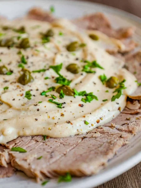 Vitello Tonnato mit dünnem Kalbfleisch, cremiger Thunfischsauce, Kapern und Petersilie