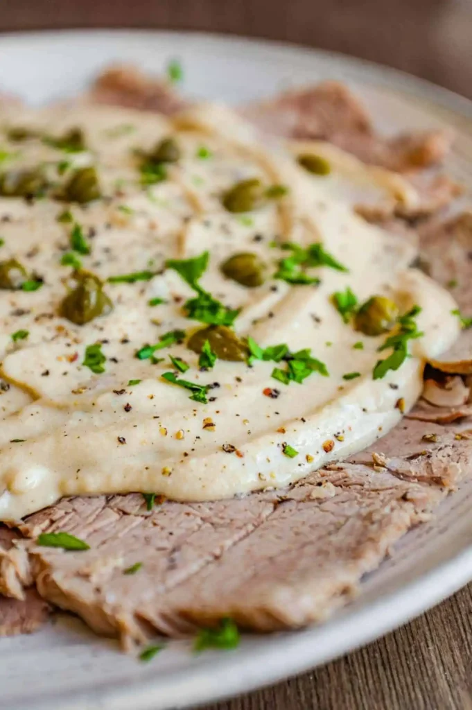 Vitello Tonnato mit dünnem Kalbfleisch, cremiger Thunfischsauce, Kapern und Petersilie
