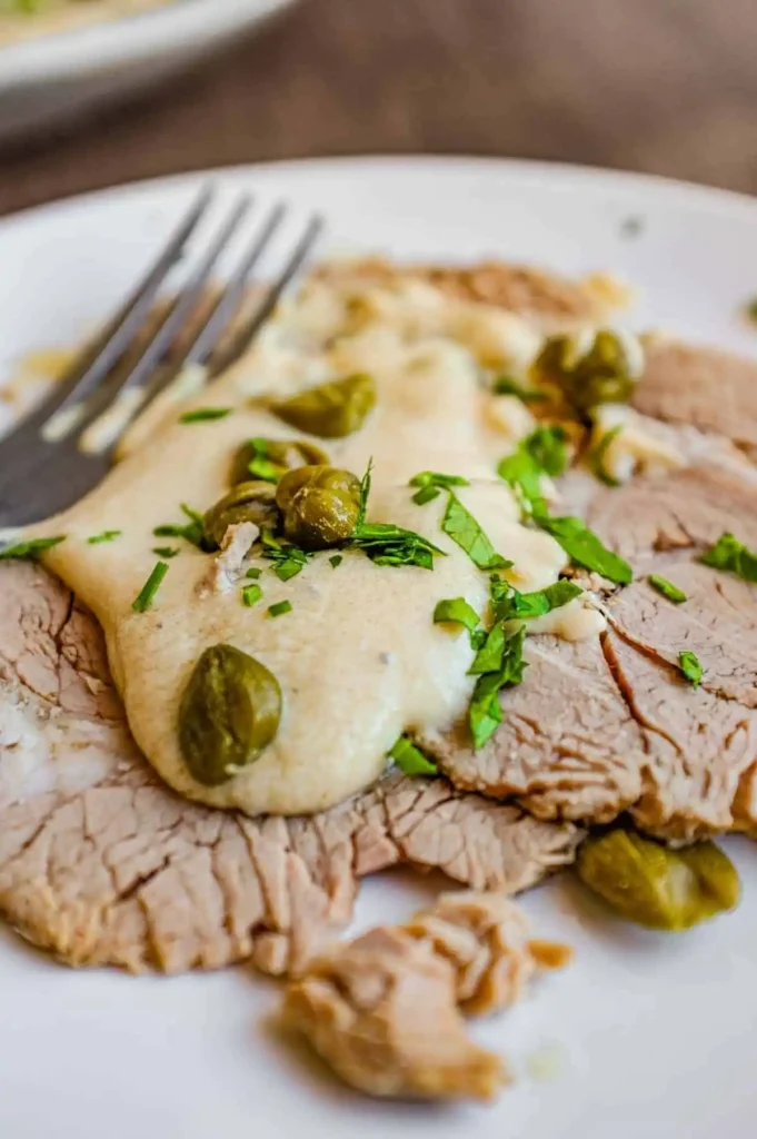 Vitello Tonnato mit dünn geschnittenem Kalbfleisch, cremiger Thunfischsauce, Kapern und Petersilie