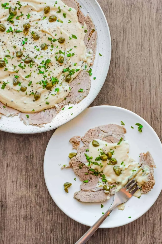 Vitello Tonnato mit dünnem Kalbfleisch, cremiger Thunfischsauce, Kapern, Petersilie und schwarzem Pfeffer