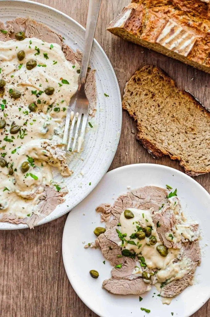 Vitello Tonnato mit dünnem Kalbfleisch, cremiger Thunfischsauce, Kapern, Petersilie und frischem Brot