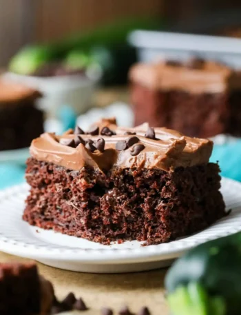 Nahaufnahme eines saftigen Zucchinikuchens mit Schokolade vom Blech, Schokoladen-Frischkäse-Frosting und Schokotropfen