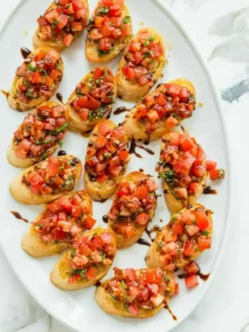 Original italienische Bruschetta mit Tomaten, Basilikum und Balsamico-Creme auf knusprig gerösteten Baguettescheiben