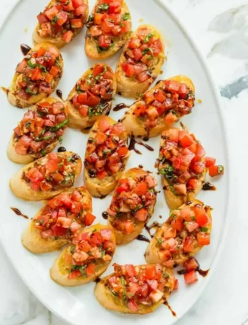 Original italienische Bruschetta mit Tomaten, Basilikum und Balsamico-Creme auf knusprig gerösteten Baguettescheiben