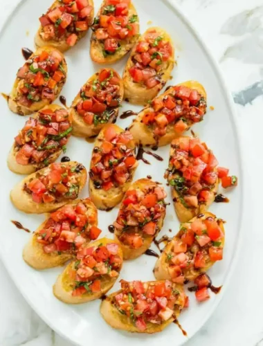 Original italienische Bruschetta mit Tomaten, Basilikum und Balsamico-Creme auf knusprig gerösteten Baguettescheiben