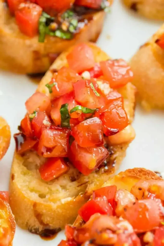 Nahaufnahme einer Bruschetta mit Tomaten, Basilikum und Knoblauch auf knusprig geröstetem Baguette