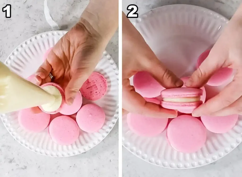 Zwei Schritte zum Füllen französischer Macarons: Creme auf eine rosa Macaron-Schale spritzen und eine zweite Schale daraufsetzen.
