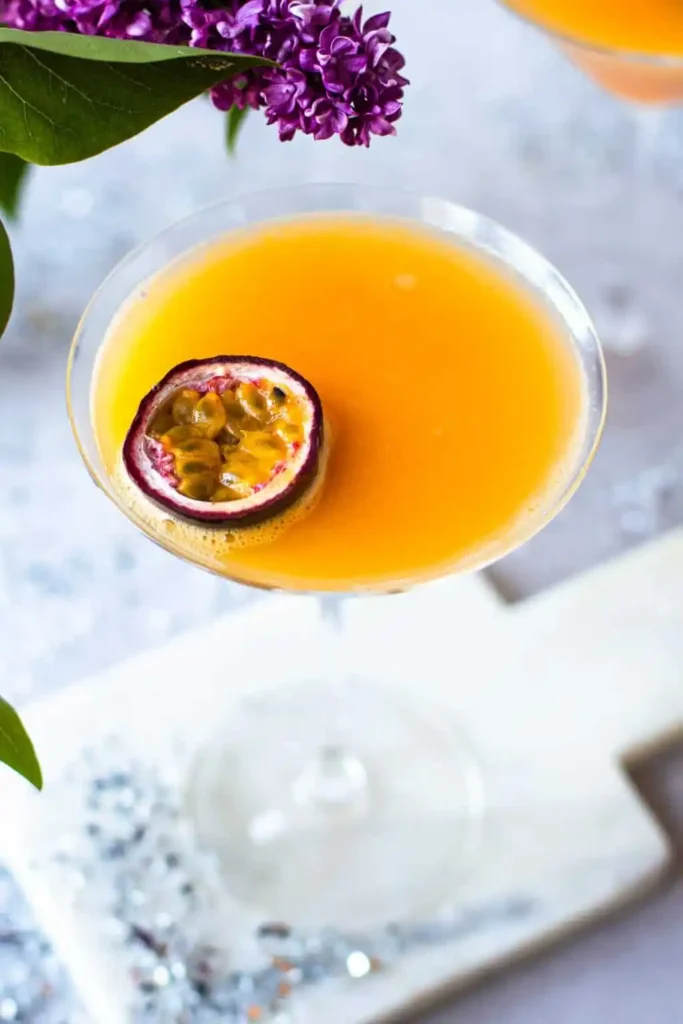 Alkoholfreier Pornstar Martini Mocktail im Coupette-Glas, garniert mit einer halben Maracuja.
