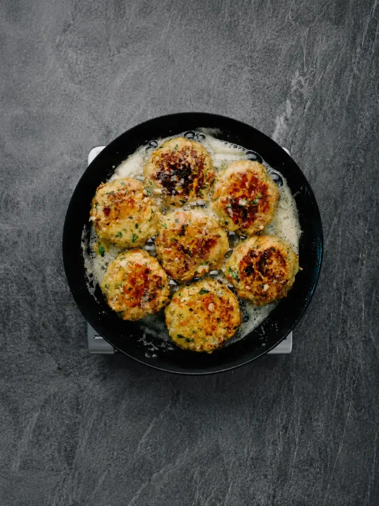 Tiroler Kaspressknödel mit Bergkäse werden in einer Pfanne goldbraun gebraten